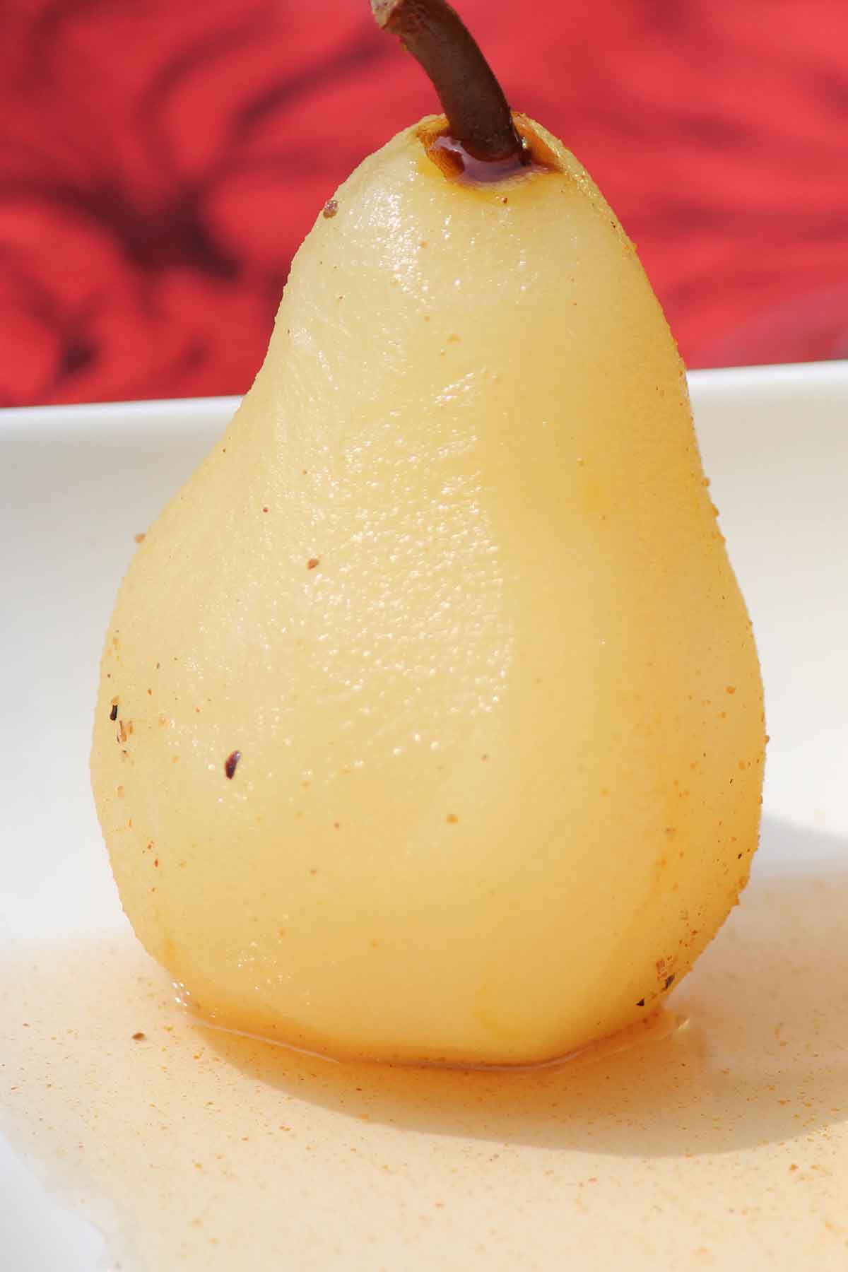 a single cinnamon poached pear with wine