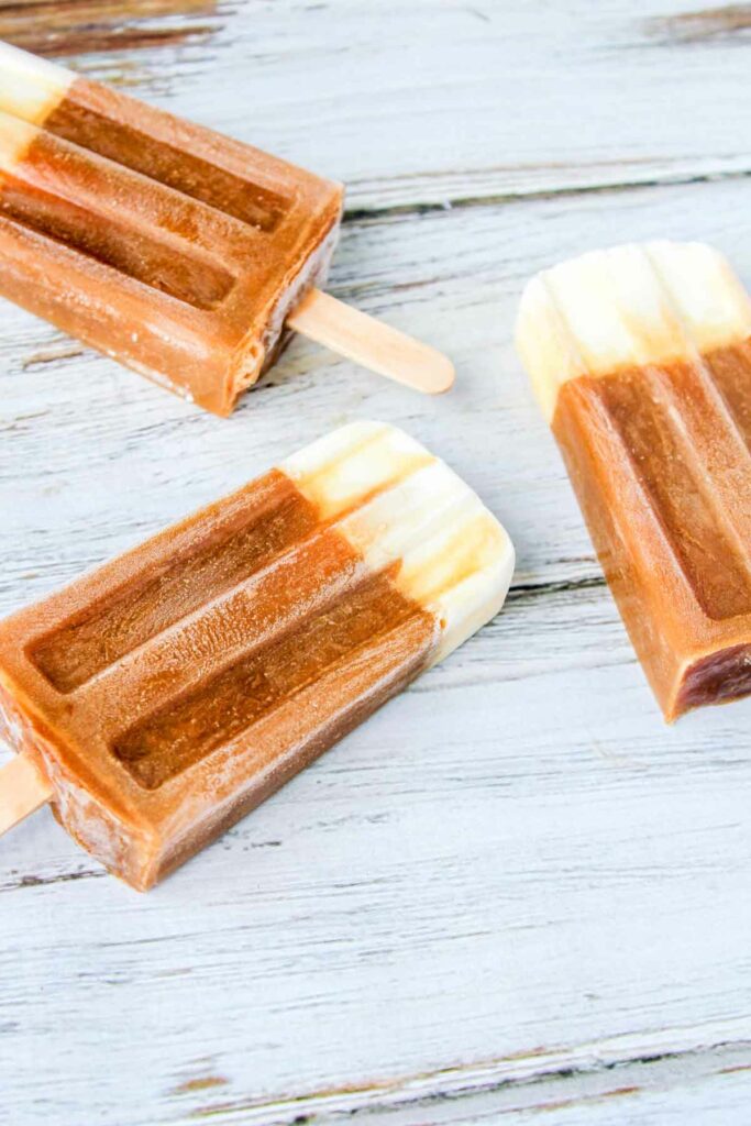 root beer float popsicles on a wood surface